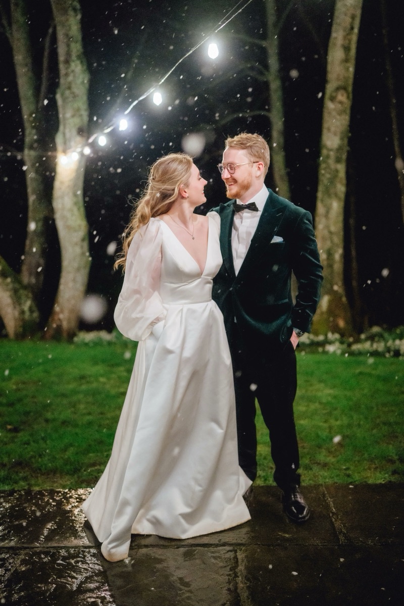 Anya and Jos under festoon lights at Dewsall Court
