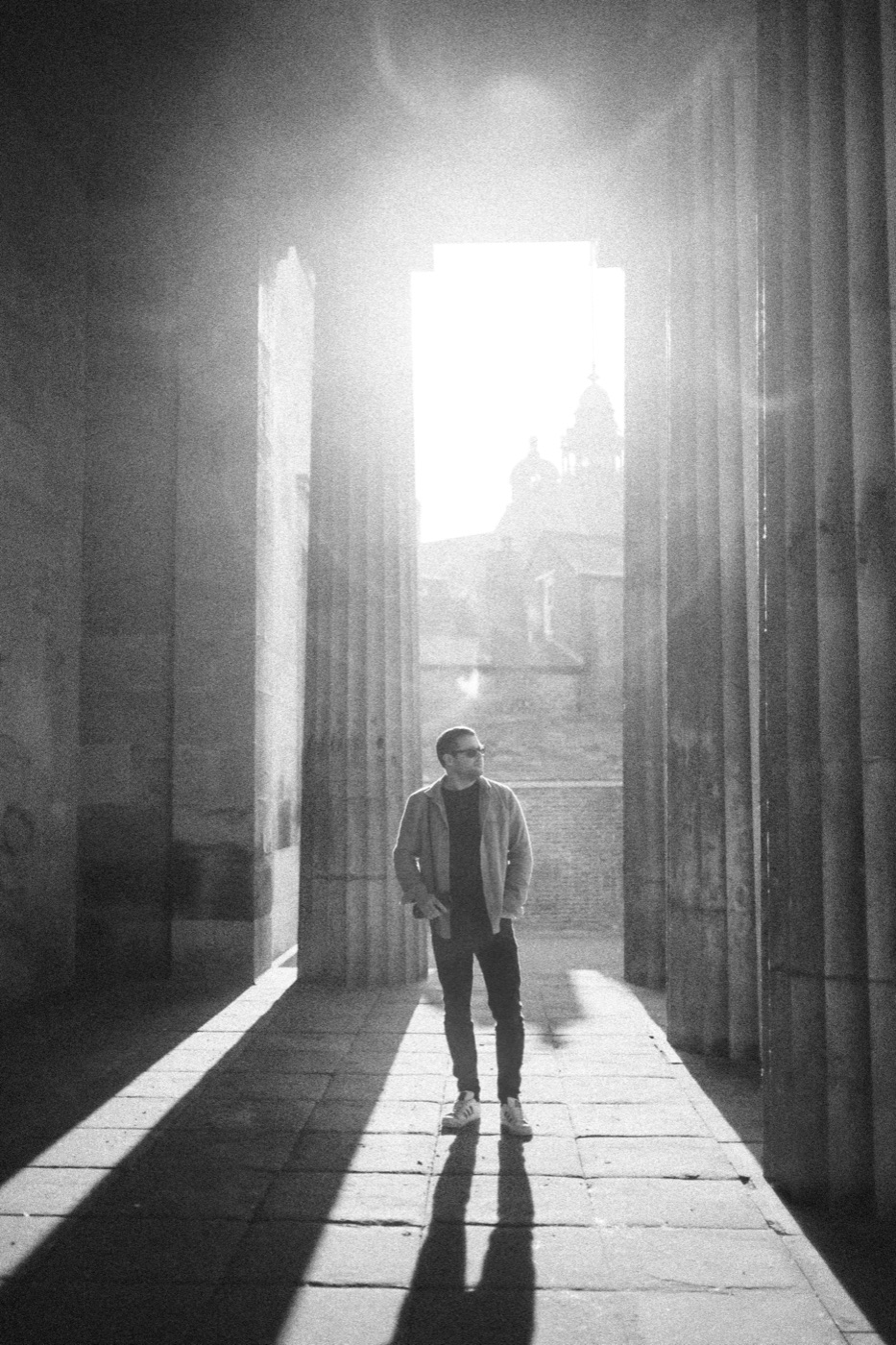 Che walking through a stone archway into the light