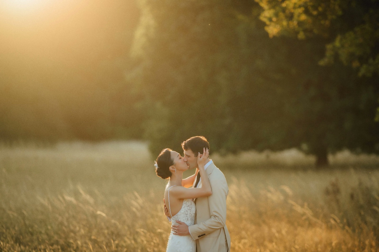 Chi and Kieran embracing in a field at golden hour
