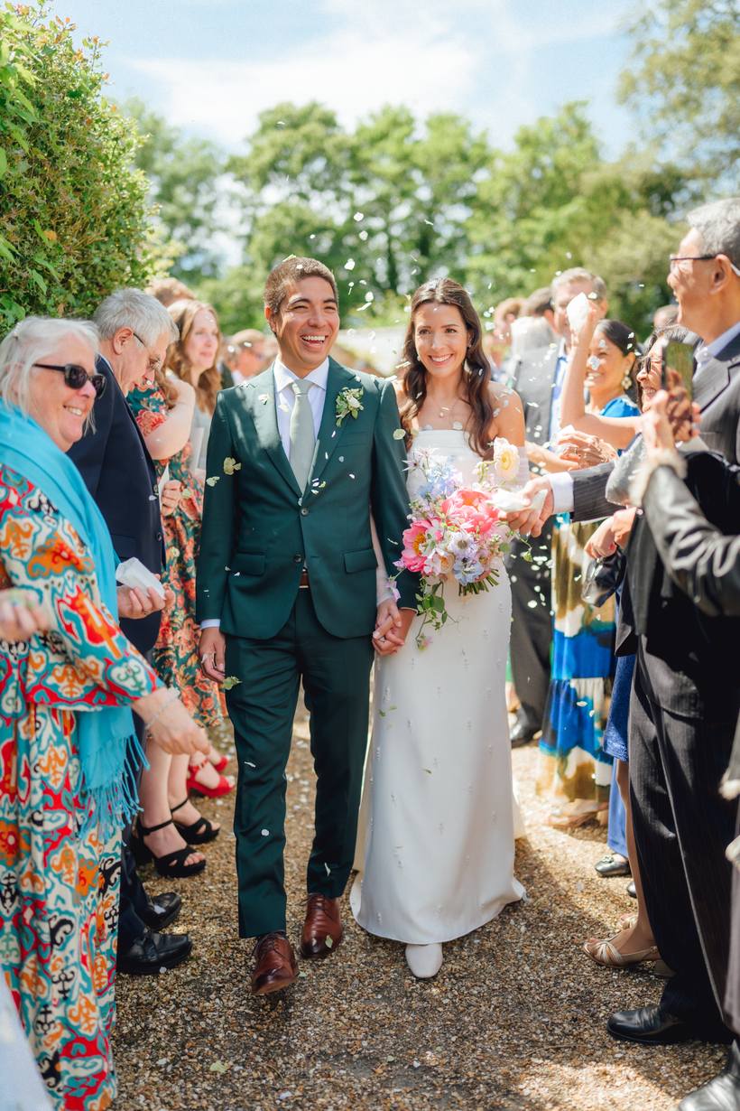 Confetti in the air as the couple pass