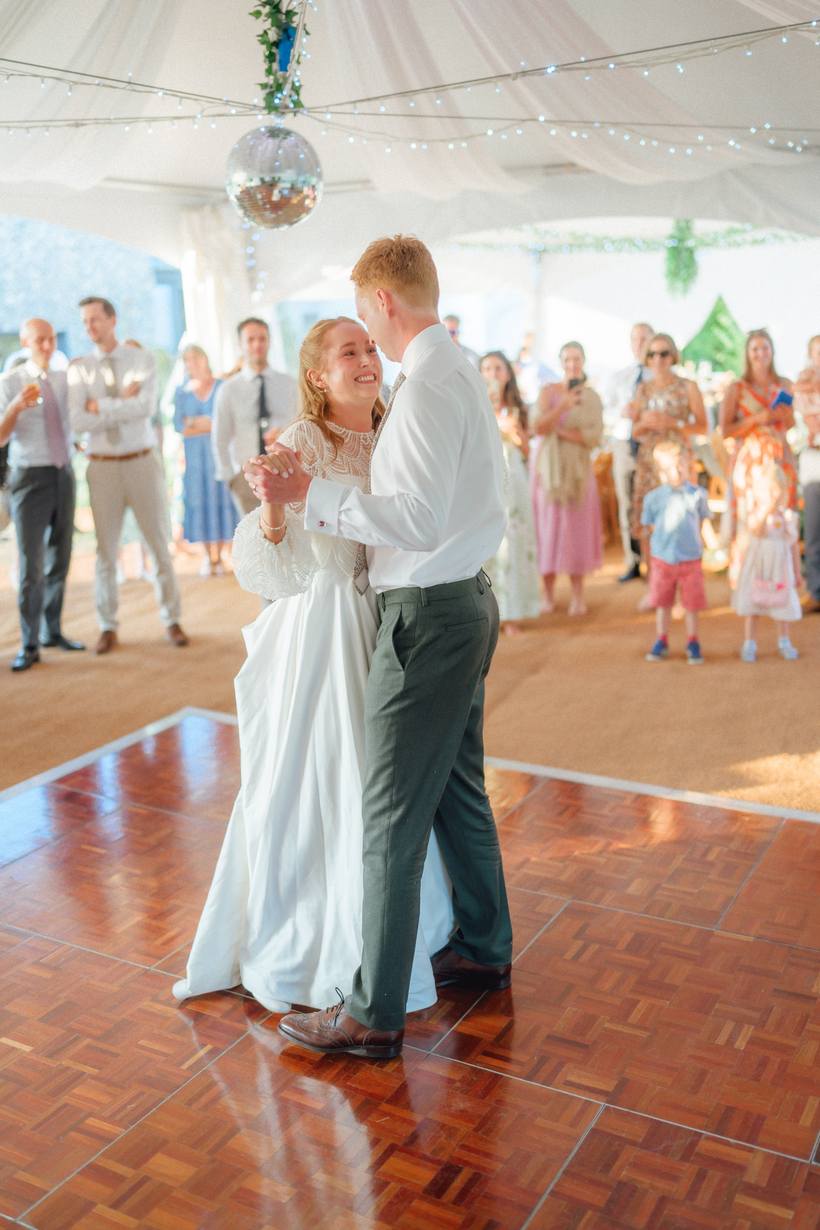 A first dance under a veil of festoon lights