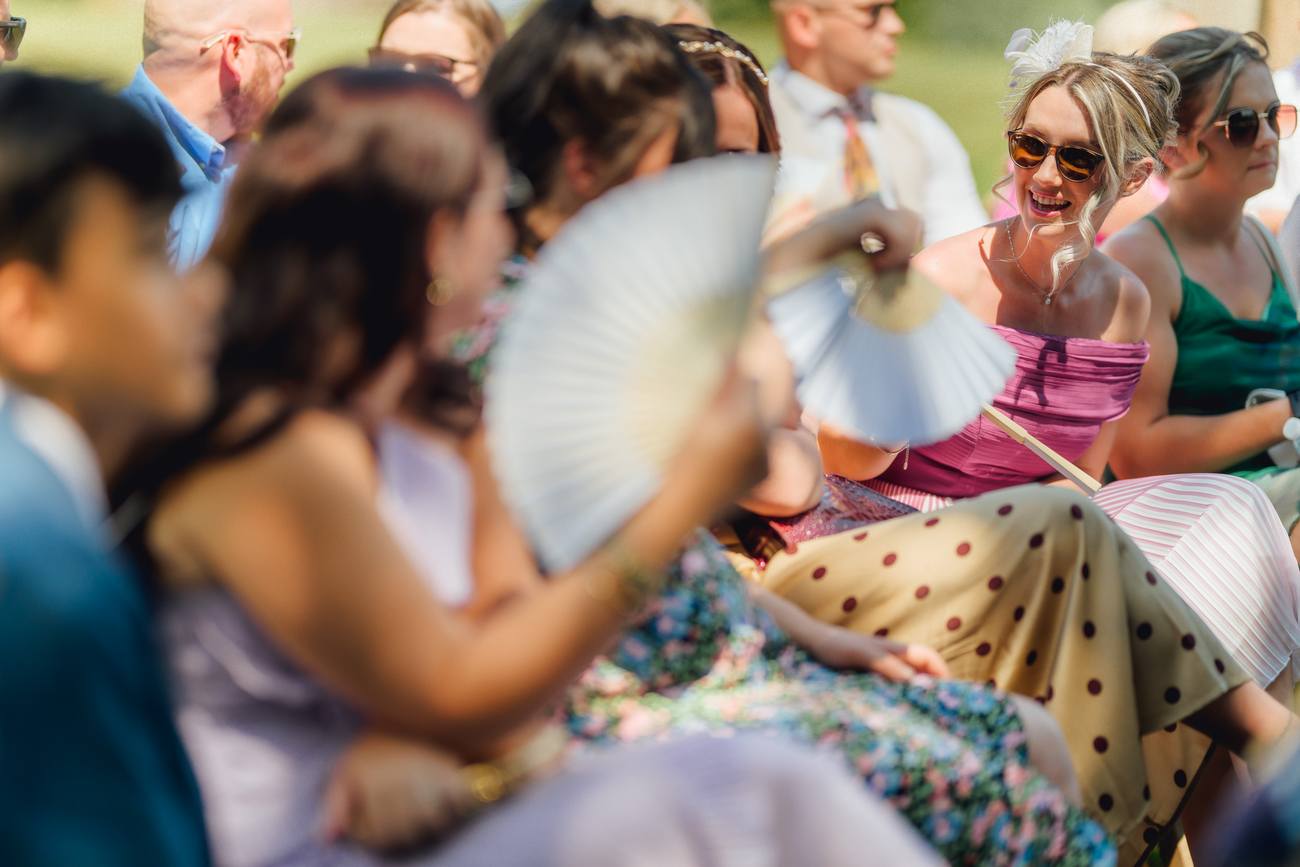 Wedding guests gathered outdoors in the summer heat